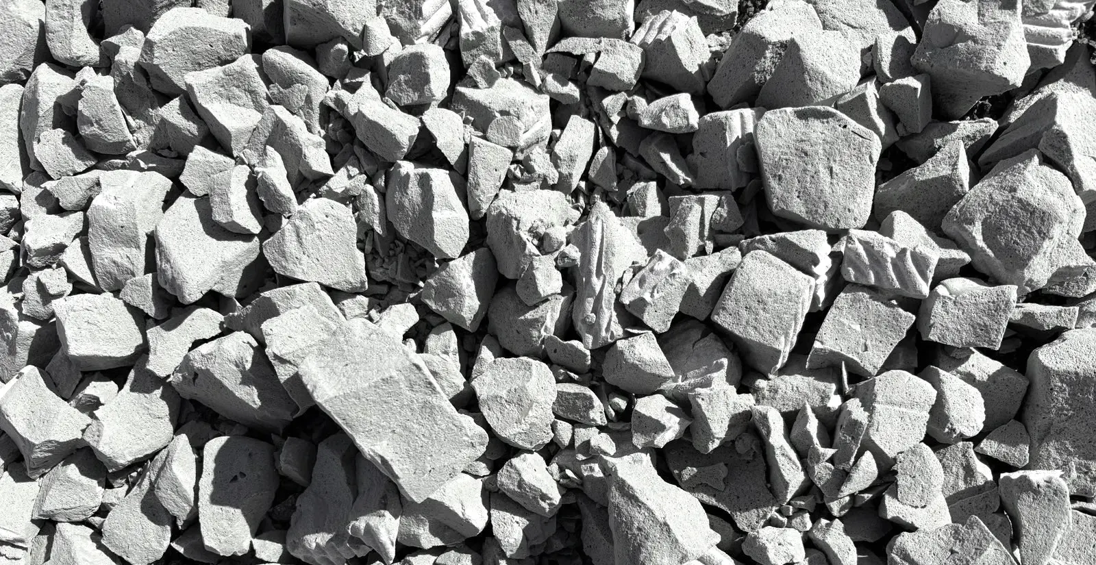 Close-up of grey, angular foam glass aggregate in a stockpile