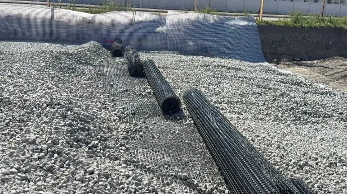 Enviro-Rock fill with rolls of geogrid laid across it on a building site