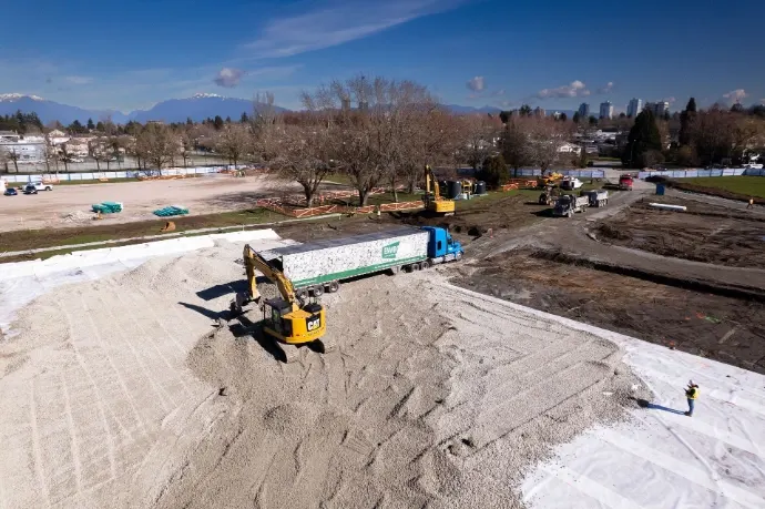 Aerial view of a sports field being filled with Enviro-Rock from a bulk trailer